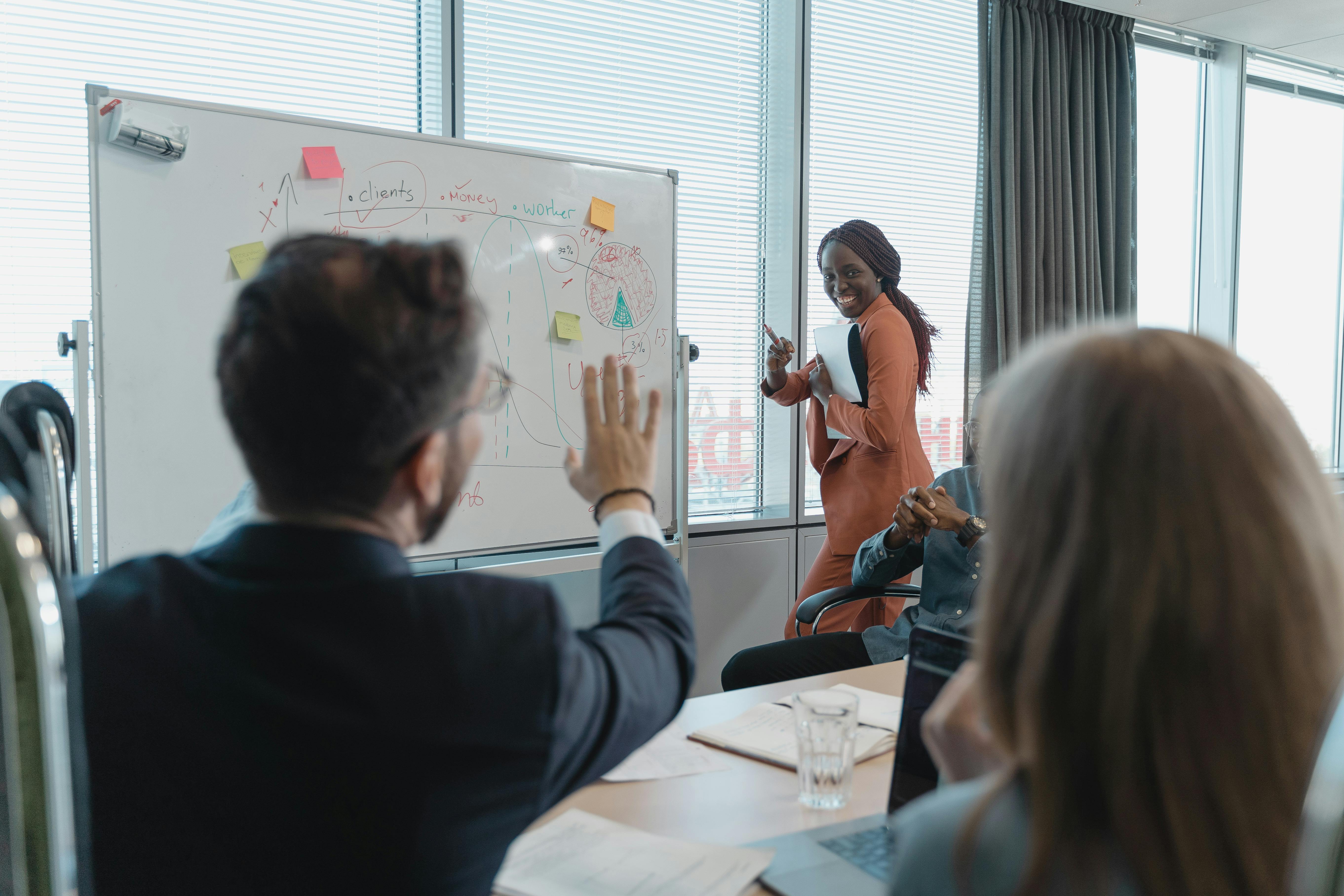 A woman presents to an audience, engaging them with her speech and visual aids in a professional setting.