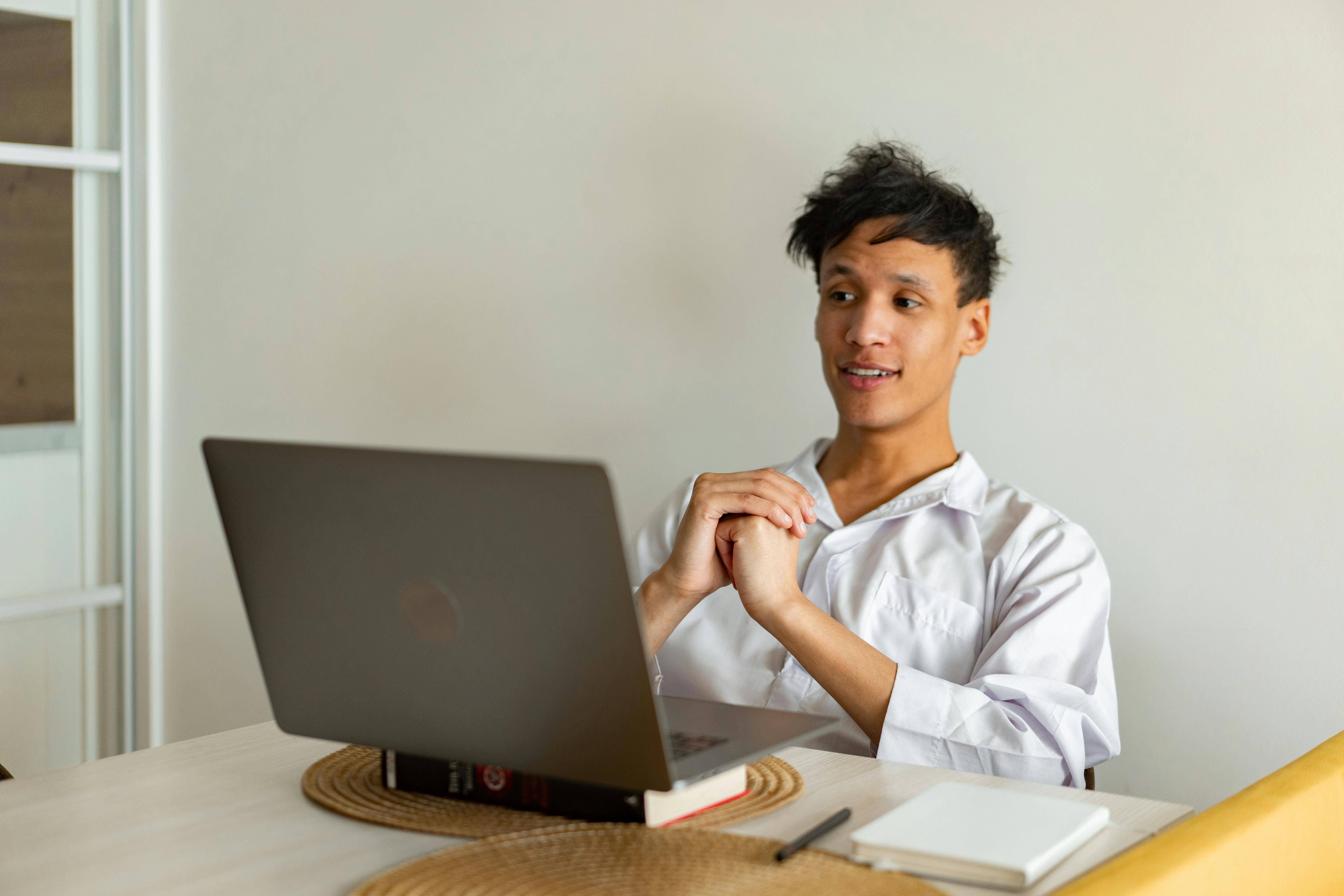 a man in a room, working on a laptop