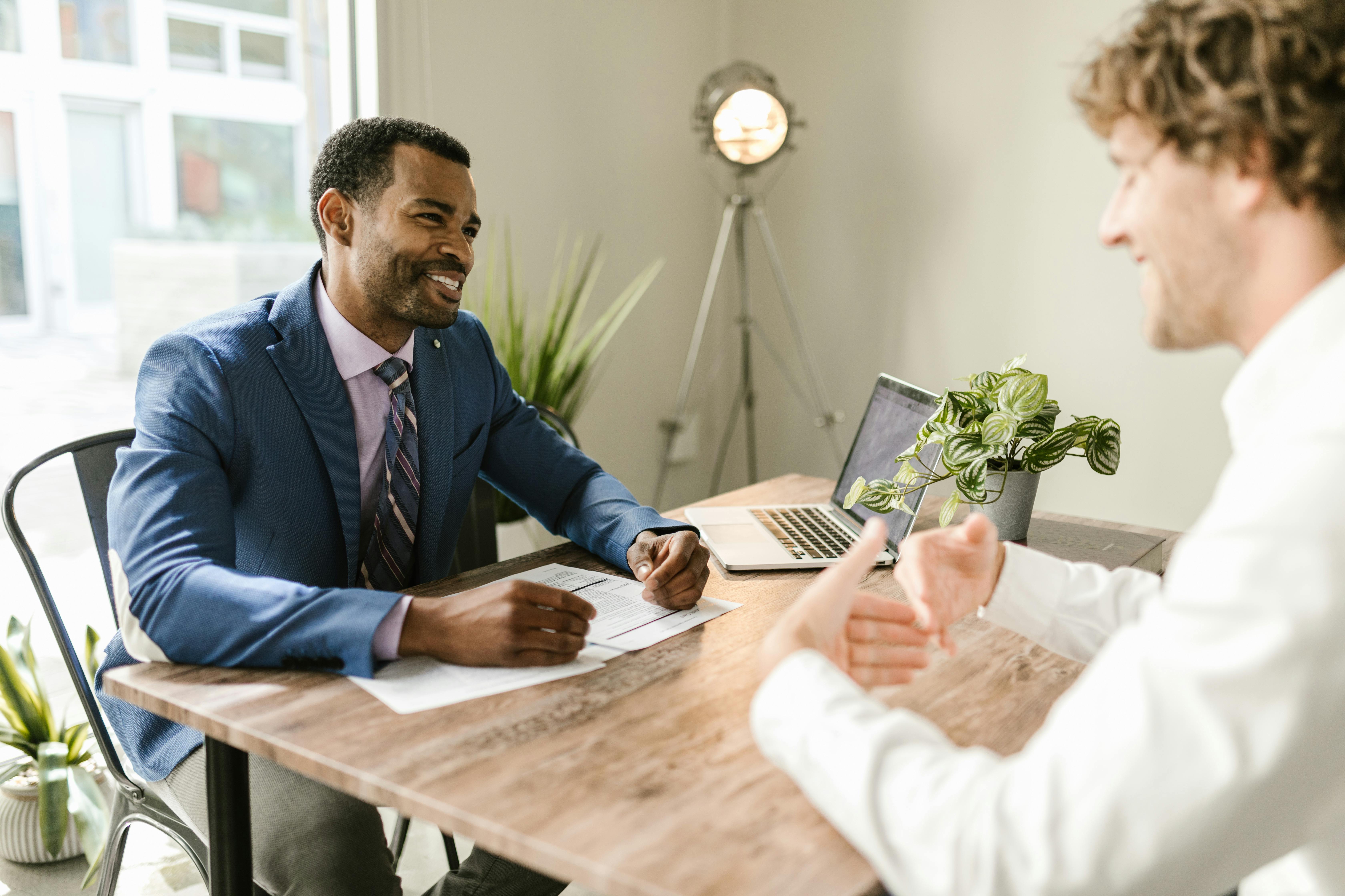 two people talking with each other sitting on a bench, insurance agents talking